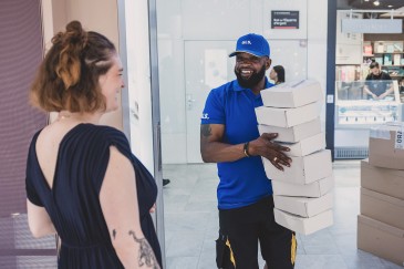 zusteller übergibt frau pakete