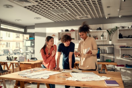 Three people look at a piece of paper