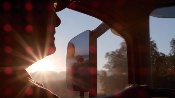 Conducteur dans sa cabine au soleil couchant