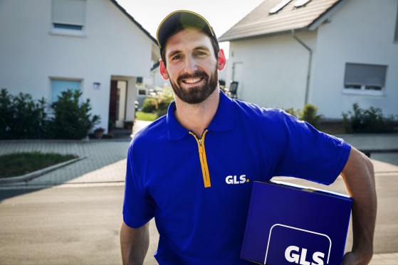 A GLS driver holding a parcel box.