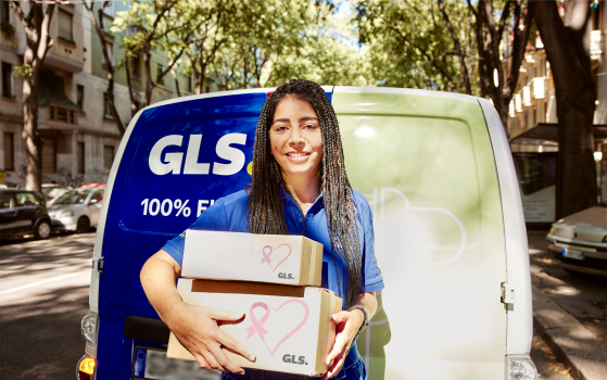 A GLS delivery woman holding parcel boxes with a printed breast cancer ribbon.