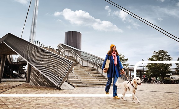 kvinde går med hund og pakke