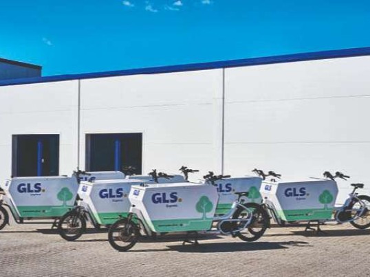 Elektrisk gls cykler klar til levering af pakker ved depot