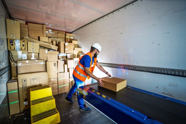 GLS operator loading parcels into a cage cart.