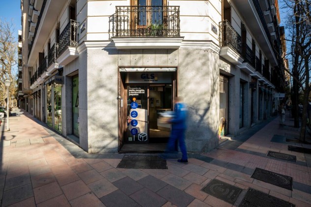 GLS Parcel Shop on a city corner, parcel pickup and shipping point with person entering the office