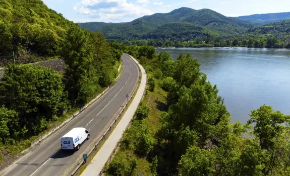 Electric delivery vehicle driving through nature
