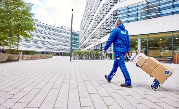 GLS:n työntekijä jakaa kärryillä paketteja kadulla.