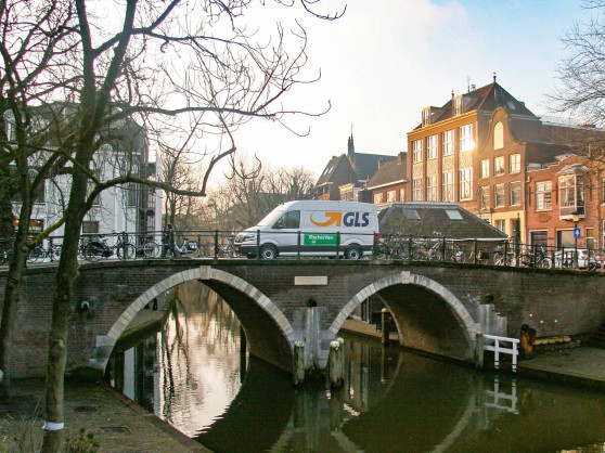 GLS van driving over a bridge in a town