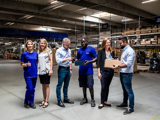 Several smiling GLS France employees in warehouse