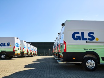 Flotte de fourgonnettes électriques GLS stationnées, illustrant l’engagement de l’entreprise vers zéro émission nette d’ici 2045.