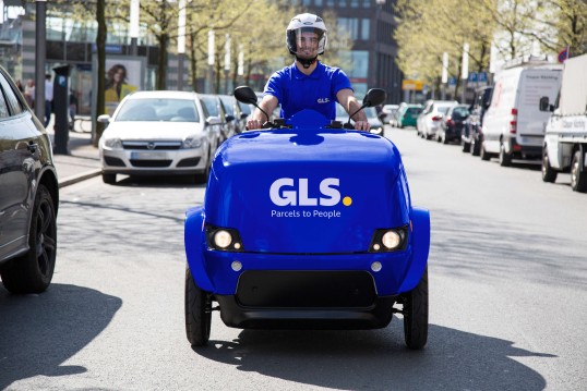 smiling delivery man driving a GLS escooter