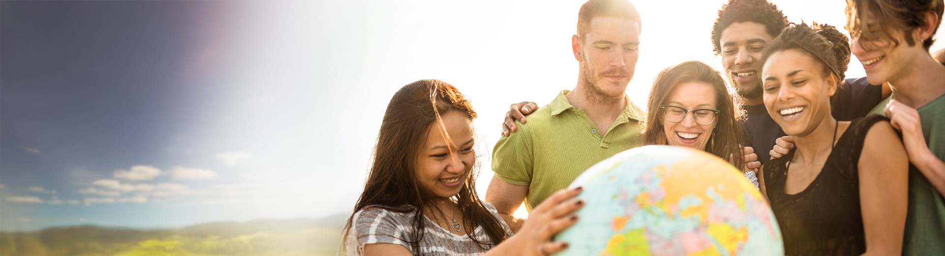 Multi-ethnic group of people observes a globe