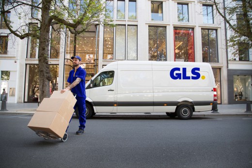 GLS courier delivering and picking a parcel to and from a shop