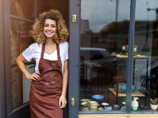 smiling girl in GLS ParcelShop is waiting for the international parcel