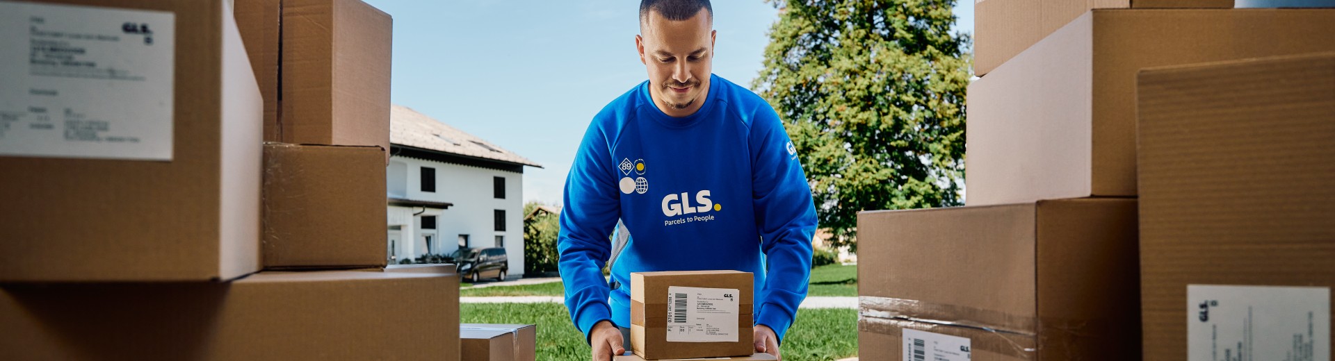 A GLS couruer with parcels in van