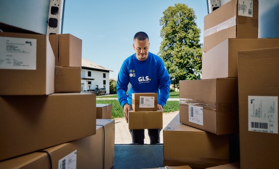 A GLS couruer with parcels in van