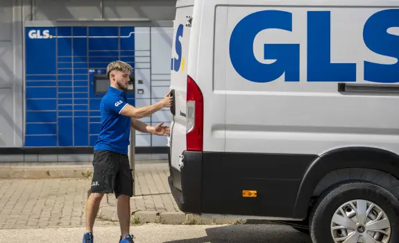 GLS courier handling parcels with a GLS van in the background