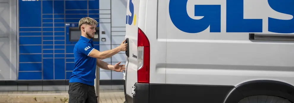 GLS courier handling parcels with a GLS van in the background