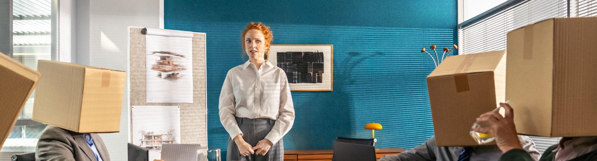 Confused woman in front of a desk with parcels instead of colleagues.